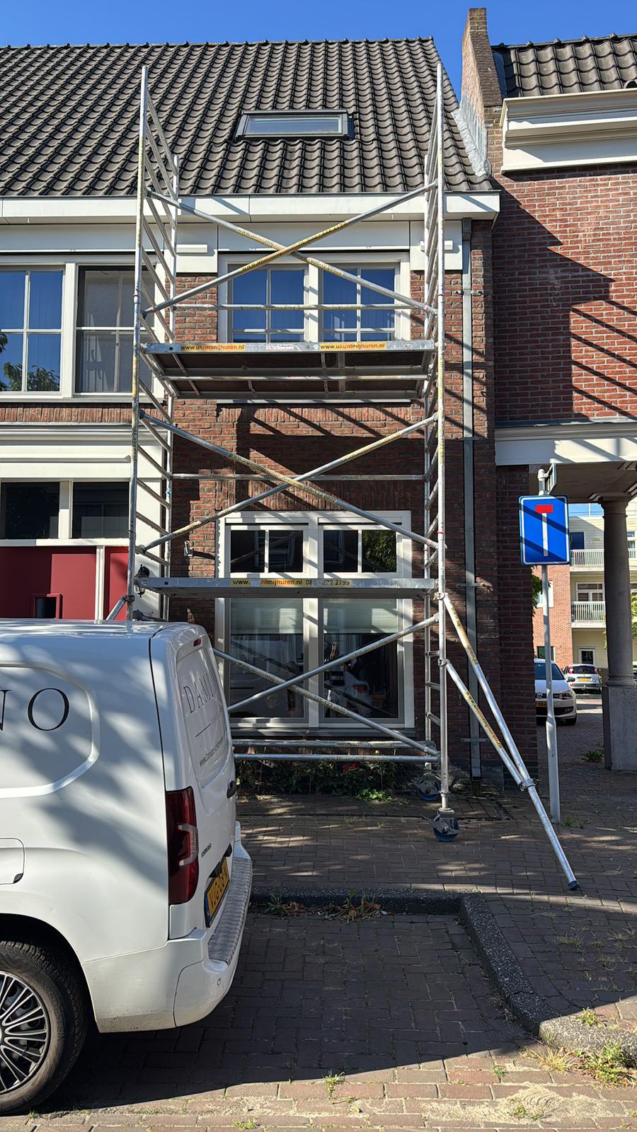 Gevelschilderwerk met steiger aan karakteristieke woning